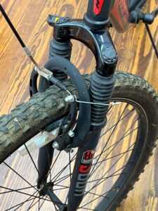 Front view of a Hyper Shocker 26 bike highlighting the suspension fork, handlebars, and knobby tires.