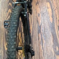 Rear view of a Hyper Shocker 26 mountain bike showing the linear‑pull brakes and rear suspension.