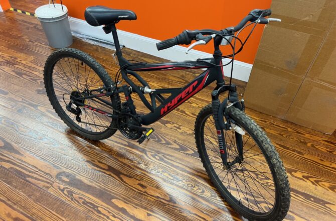 Side view of a Hyper Shocker 26 mountain bike showing the steel full‑suspension frame and 26‑inch wheels.