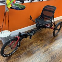 Front view of a Hase Trigo Nexus showing the upright seating, delta frame, and front wheel.