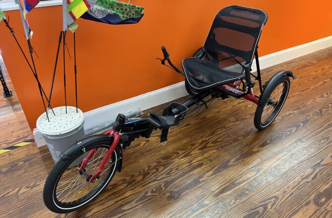 Front view of a Hase Trigo Nexus showing the upright seating, delta frame, and front wheel.