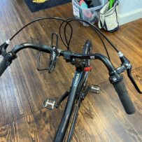 Hase Trigo Up recumbent trike, handlebar view with upright seat and steering column.