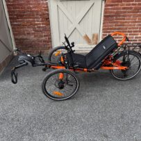 Side view of used Catrike eCAT Villager in Atomic Orange sale at Lancaster Recumbent